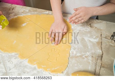 Hands Of Mother And Son Who Squeeze Cookie Figures On The Dough. Cooking At Home