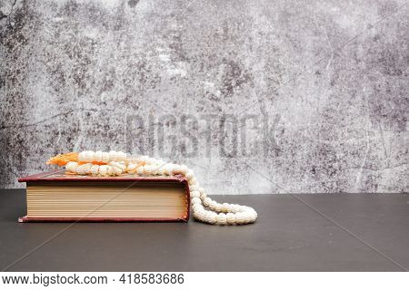 A Picture Al-quran With Tasbih At Isolated Copyspace Crack Wall For 