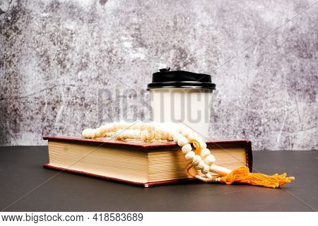 A Picture Of Holy Quran With Tasbeeh And Empty Paper Cup On Isolated Crack Wall Background For 