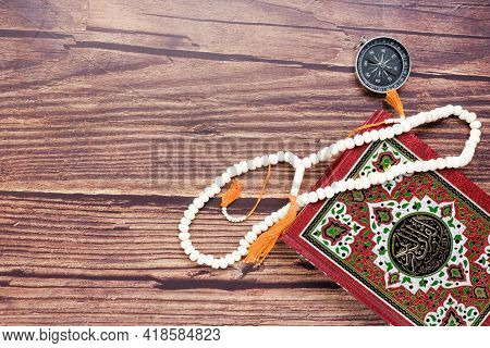 Quran Is Your Guidance Of Your Life Concept With The Koran, Prayer Beads And Compass On Copyspace. L
