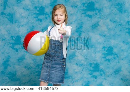 Little Girl Is Playing With A Ball.the Concept Of Childrens Sports, Summer Outdoor Recreation.