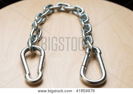 Carbiners og kæde på træbord
