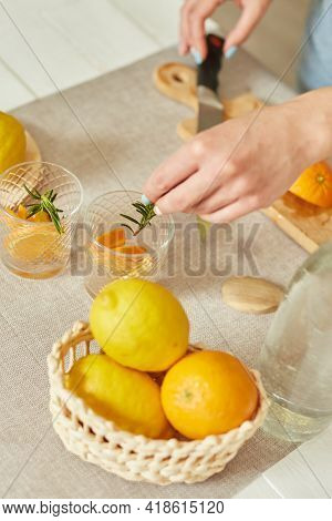 Female Hand Put Rosemary In Glasses, Making Fresh Lemonade