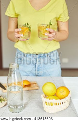 Female Woman Hand Hold Two Glasses Of Citrus Orange And Rosemary Fresh Lemonade