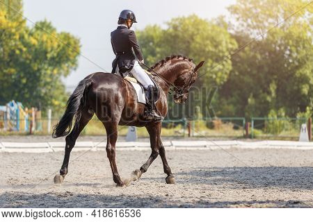 Young Girl Riding Horse At Dressage Advanced Test