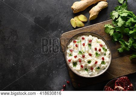 Curd Rice With Pomegranate, Cilantro, Mustard Seeds, Ginger On A Black Background. Indian Cuisine