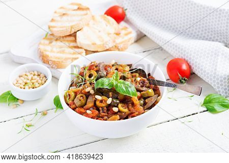 Traditional Italian Caponata And Toast On A Wooden White Table. Sicilian Caponata.