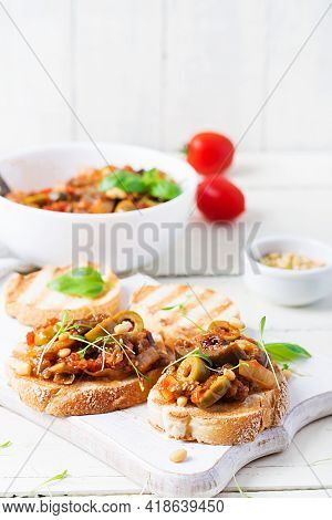 Traditional Italian Caponata And Toast On A Wooden White Table. Sicilian Caponata.