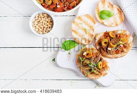 Traditional Italian Caponata And Toast On A Wooden White Table. Sicilian Caponata. Top View, Above, 