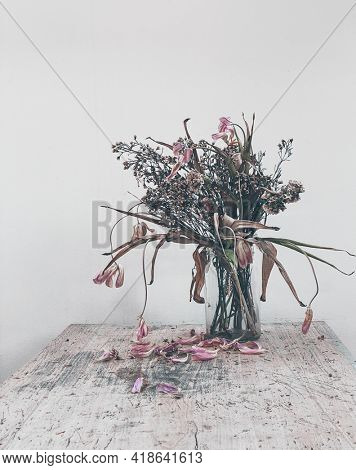 wilted flowers bouquet in a clear glass vase ,Vintage filtered