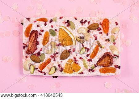 Handmade Pink Chocolate Bar With Dried Fruits And Nuts On A Fastive Pink Background.