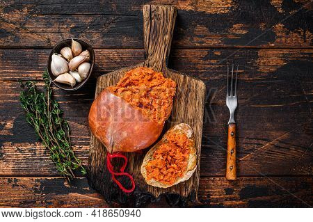 Sobrassada Cured Pork Meat Sausage On Bread Slice. Dark Wooden Background. Top View
