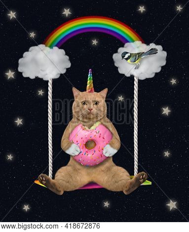 A Reddish Cat Unicorn With A Pink Donut Sits On A Cloudy Swing Under A Rainbow At Night.