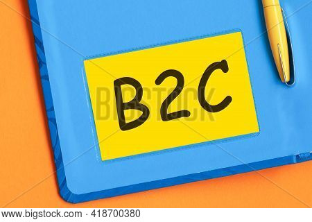 The Letters B2c Is Written In Black Letters On Yellow Note Paper. A Yellow Pen Is Embedded In The Ba