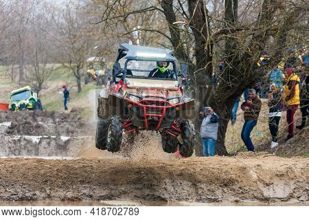 Afipsip, Russia - October 31, 2020: Sportsman On Buggy Jumps In Air Splashing With Dirt And Water At