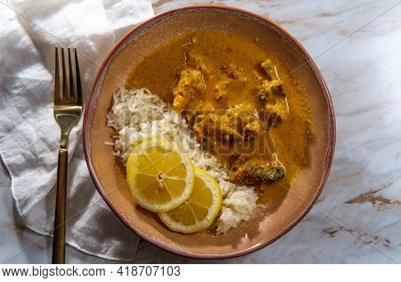 African Chicken Curry Also Known As Kuku Paka, Served With Rice And Sliced Lemon