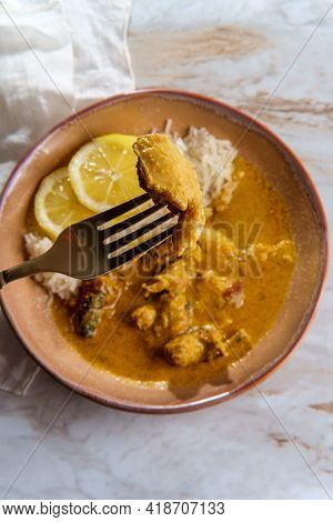 African Chicken Curry Also Known As Kuku Paka, Served With Rice And Sliced Lemon