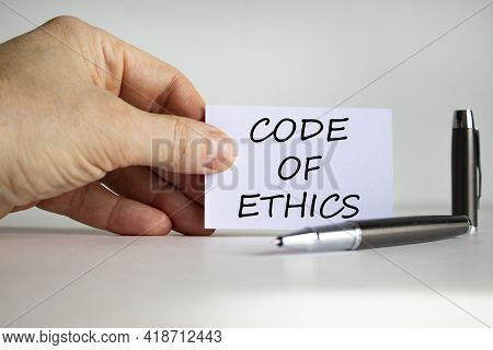 Code Of Ethics Symbol. White Paper With Words 'code Of Ethics' In Businessman Hand, Metalic Pen. Bea