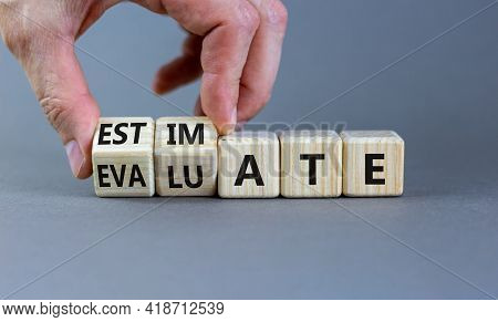 Estimate Or Evaluate Symbol. Businessman Turns Wooden Cubes And Changes The Word 'evaluate' To 'esti
