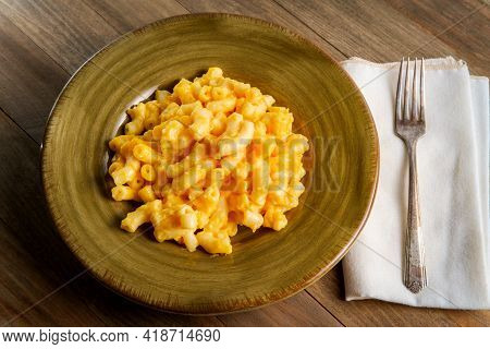 Delicious Macaroni And Cheese On Wooden Table With Dramatic Dark And Moody Lighting