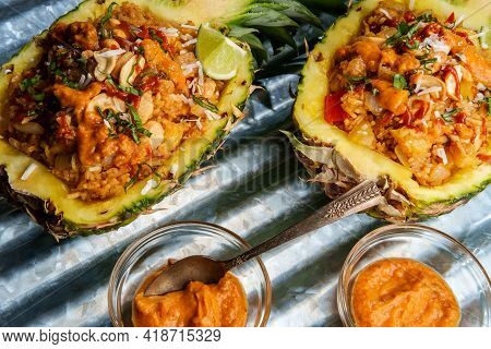 Thai Cashew Chicken Fried Rice Served In A Pineapple Bowl With Sriracha And Peanut Satay Sauce