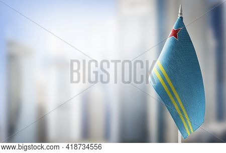 A Small Flag Of Aruba On The Background Of A Blurred Background