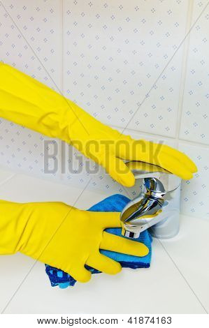 il lavandino del bagno è pulito con guanti in lattice.
