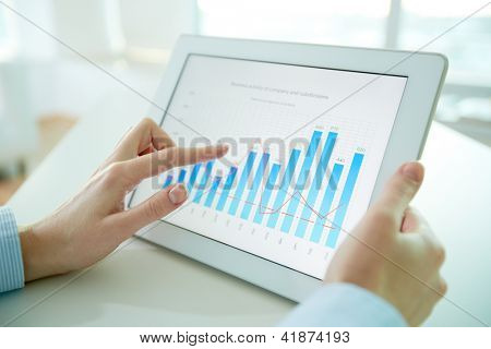 Kvindelig arbejdstager analysere finansielle resultater ved hjælp af en digital pad