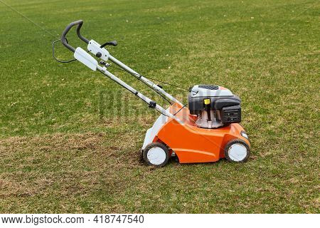 Orange Grasscutter Standing On Ground On Green Grass, Special Equipment For Trimming Grass, Grass-mo