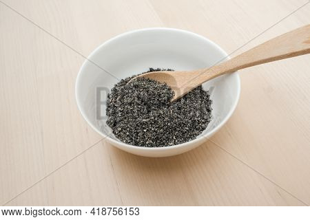 Mixed white and black roasted sesame roasted black sesame seeds finely ground in wooden spoon