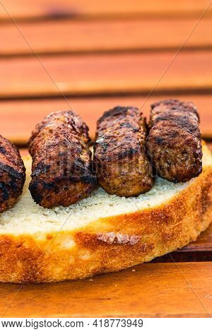 Meat Rolls Called Mici Or Mititei On A Slice Of Bread Isolated