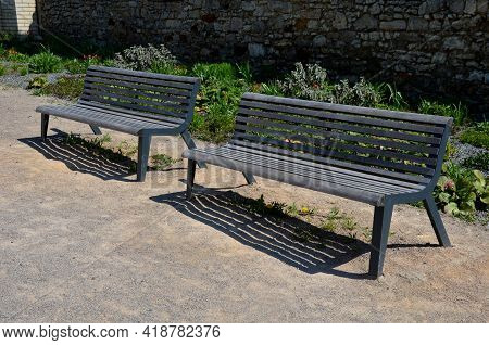 Perennial Bed Mulched With Gray Gravel In Front Of A Limestone Stone Wall In A Square With Benches W