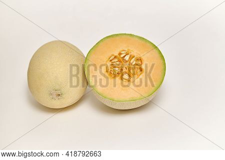 Whole And Sliced Japanese Melon, Honey Melon Or Cantaloupe (cucumis Melo) On A White Background