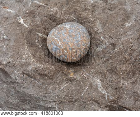 Round Stone - A Large Sea Pebble Lies In A Recess Of The Rock