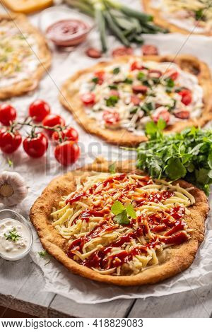 Lovely Wooden Desk Full Of Crusty Hungariand Langos Served With Cheese, Vegetables, Ham, Ketchup, Di
