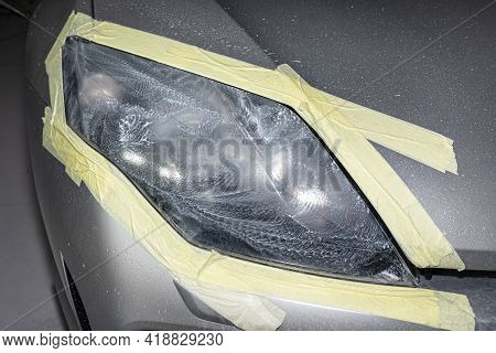 The Headlight Is Covered With Abrasive Paste And Secured With A Protective Tape, Prepared For Polish