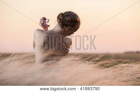 Young Woman Enjoying Smell Of Perfume