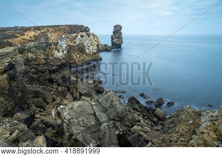 Long Exposure Seascape Of The Cliffs Of Papoa Island In Carvoeiro Cape From The Sea At Sunrise In A 