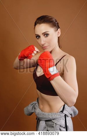 A Studio Portrait Of An Attractive Caucasian Young Woman Fighter With Bandages On Her Fists Preparin
