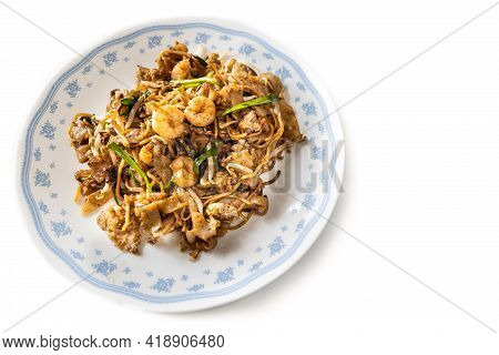 Overhead View Of Penang Char Kuey Teow Is Popular Fried Noodle With Coceral, Shrimp And Eggs In Blac