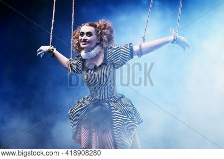 The actress plays a doll on strings at a performance in a puppet theater. A portrait in retro style.