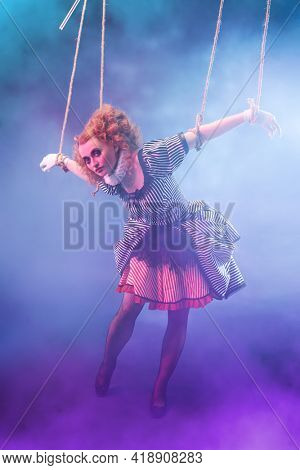 Puppet theater and circus. The actress plays a doll on strings at a performance in a puppet theater. Full length portrait in vintage style.