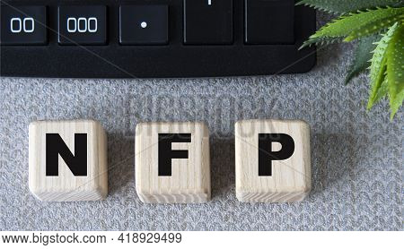 Nfp - Acronym On Wooden Cubes On A Gray Background With A Calculator. Business Concept
