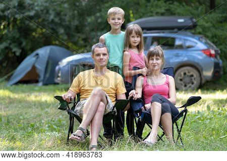 Happy Family Parents And Kids Resting Together At Campside.