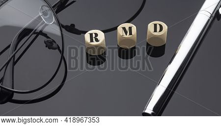 Rmd Concept, Words On Wooden Blocks On Black Background With Pen And Glasses.