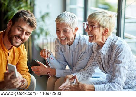 Group of satisfied colleagues socialazing on a break in the office