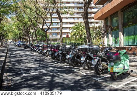 Spain, Barcelona, March, 2021: Motorbike Group Parking On Urban Greening And Quiet Street Of Sarria 