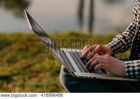 Male Hands Typing On Laptop In The Park