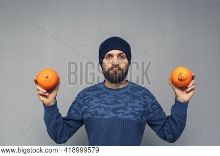Bearded Man Shows Normal And Ugly Oranges, Concept Of Hemorrhoids Or Proctological Diseases.