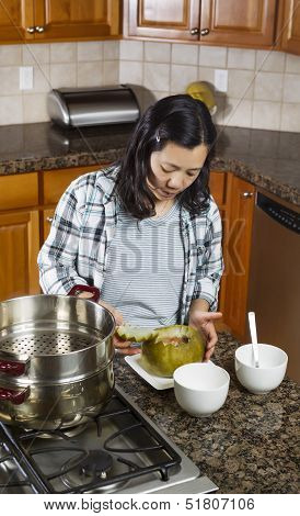 Mature Woman Putting The Finishing Touches On Cooked Winter Melon For Dinner